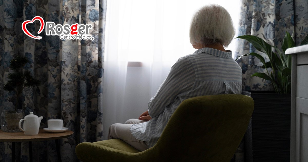 Persona adulta mayor sentada junto a una ventana, imagen del Día Mundial del Alzheimer de Rosger.